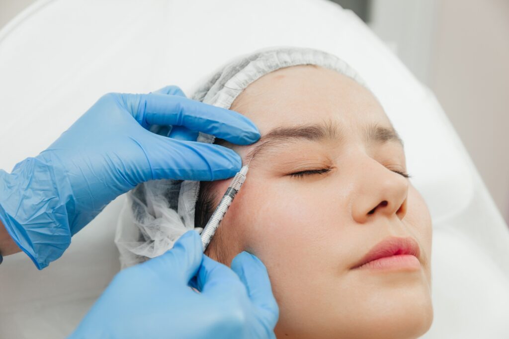 Beautician injecting Botox into a woman's forehead at Alladerm medical spa